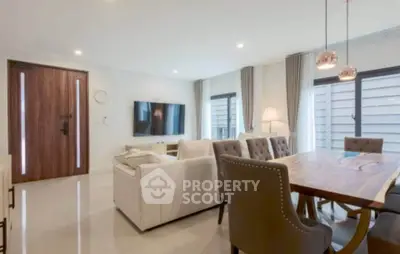 Spacious modern living room with elegant dining area and large windows.