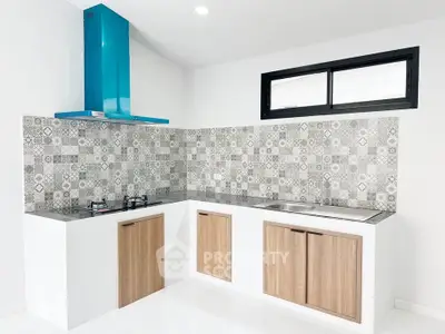 Modern kitchen with stylish backsplash and blue range hood