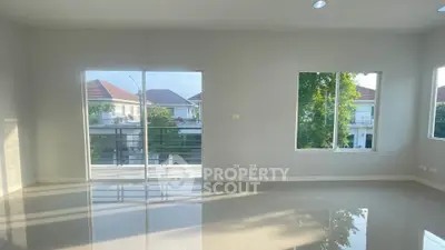 Spacious living room with large windows and balcony view in modern home