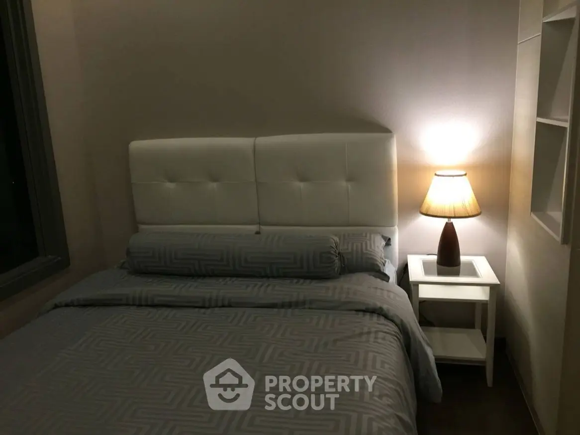 Cozy bedroom with stylish lamp and modern bedding in a serene setting.