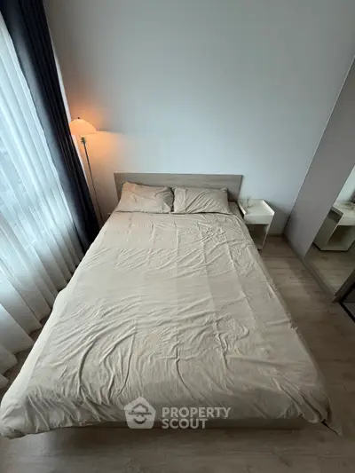 Cozy bedroom with natural light and modern decor, perfect for relaxation.