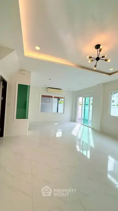 Spacious modern living room with elegant lighting and large windows for natural light.
