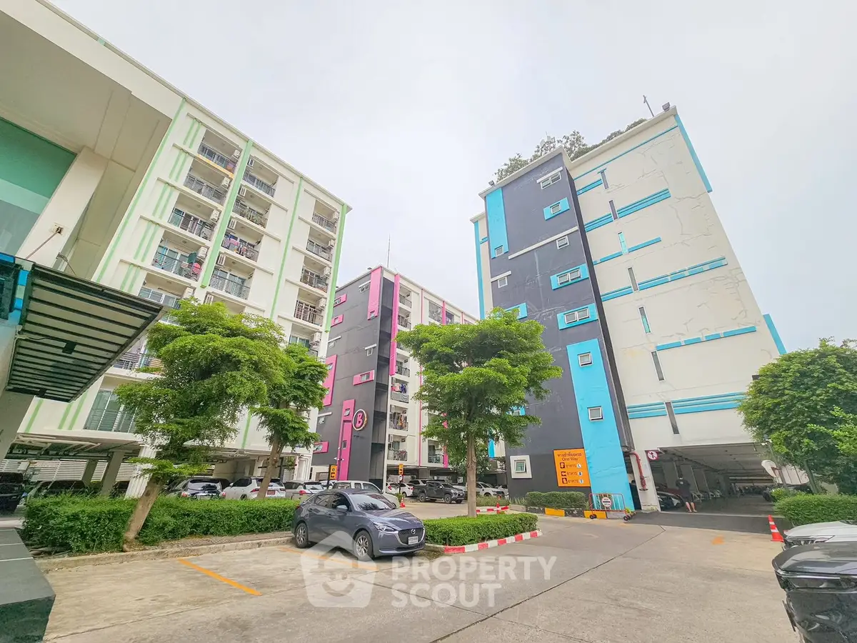 Modern apartment complex with colorful facades and ample parking space