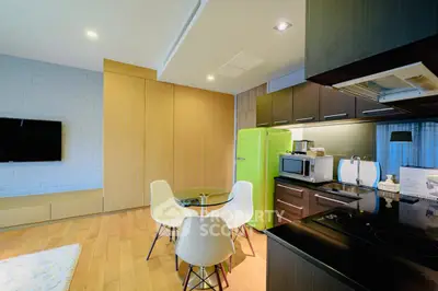 Modern kitchen with vibrant green fridge and sleek appliances in open layout
