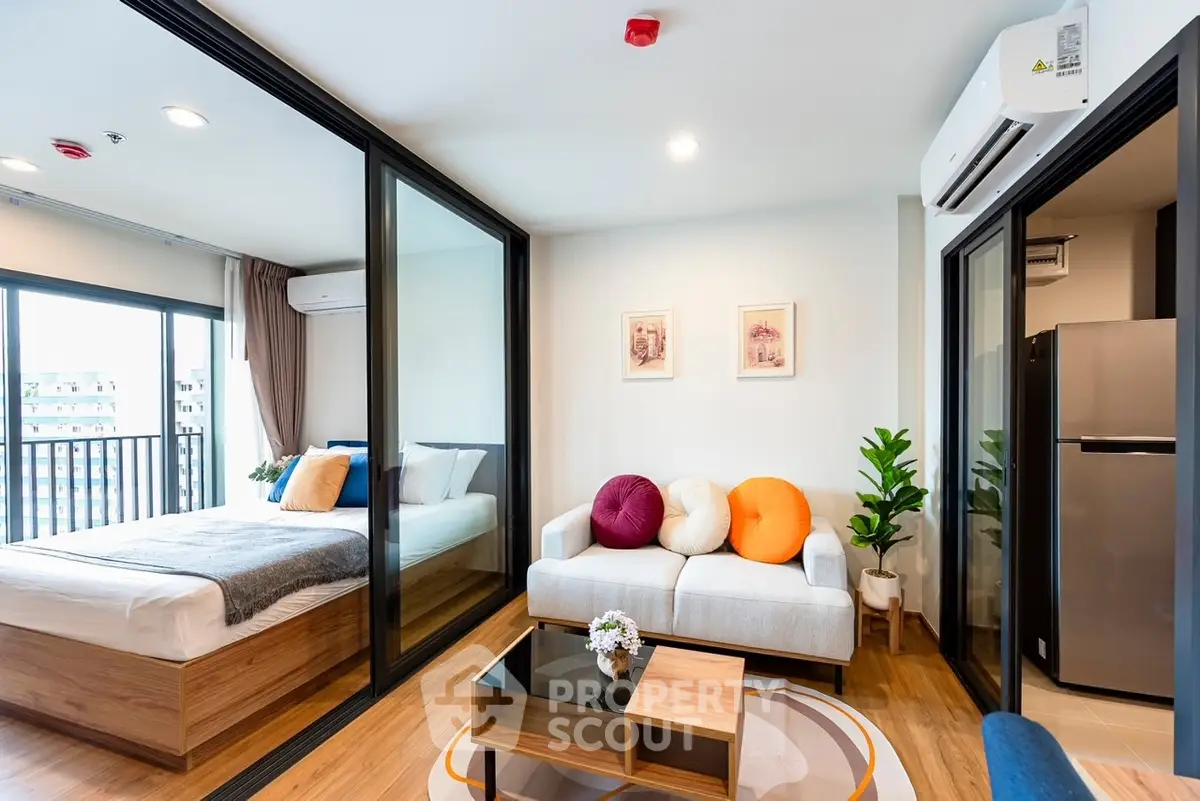 Modern studio apartment with glass partitions, cozy living area, and stylish decor.