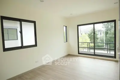 Spacious empty room with large windows and balcony view
