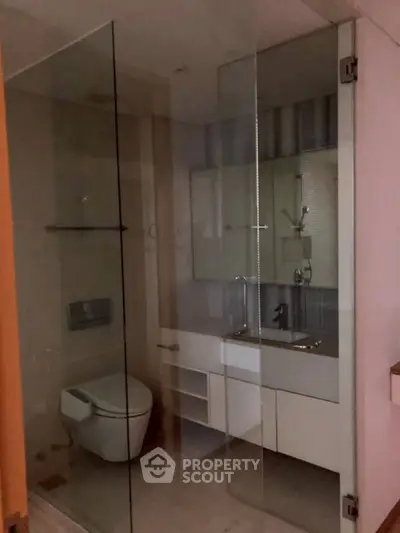 Modern bathroom with glass shower enclosure and sleek fixtures