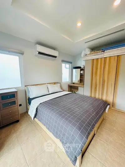 Modern bedroom with stylish wooden furniture and air conditioning, perfect for comfort and relaxation.
