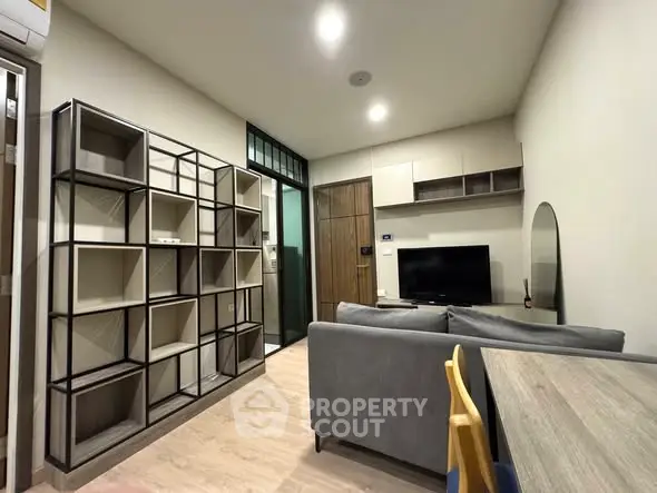 Modern living room with stylish shelving and cozy seating area in a contemporary apartment.