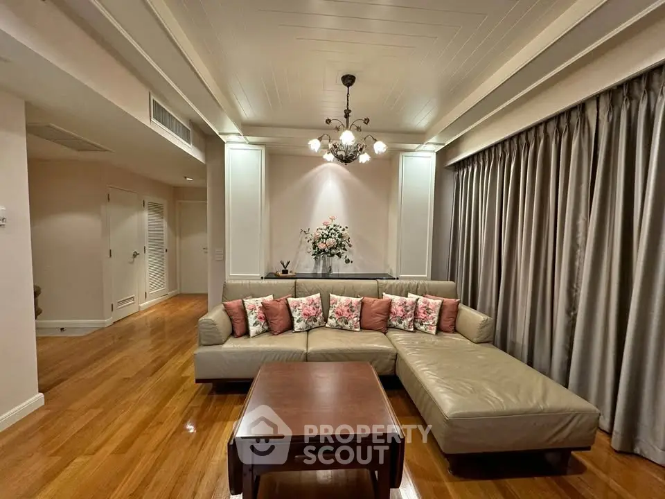 Elegant living room with plush sectional sofa and chic chandelier lighting.
