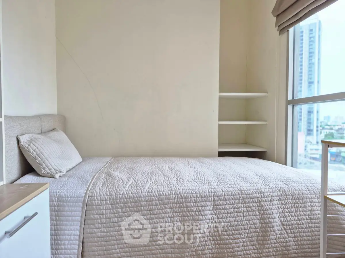 Cozy bedroom with city view, featuring a single bed and minimalist decor, perfect for urban living.