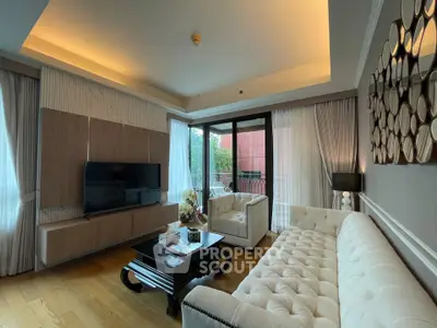 Luxurious living room with elegant decor and large windows opening to a balcony.