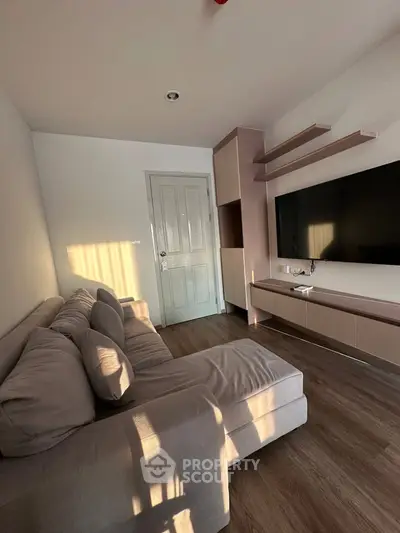 Cozy living room with modern TV setup and plush sectional sofa, perfect for relaxation and entertainment.