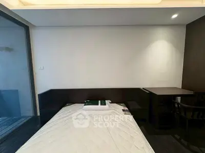 Modern bedroom with minimalist design and large window for natural light.