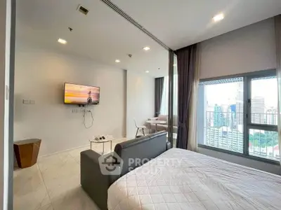 Modern bedroom with city view, featuring sleek furniture and large windows for natural light.