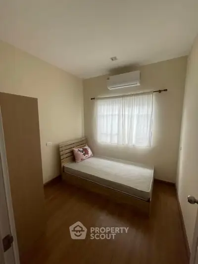 Cozy bedroom with wooden flooring and natural light