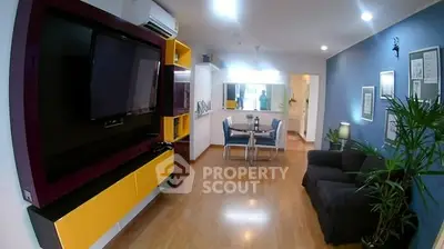 Modern living room with stylish decor and open layout, featuring a wall-mounted TV and sleek furniture.