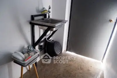 Compact utility area with sink and dish rack in minimalist design