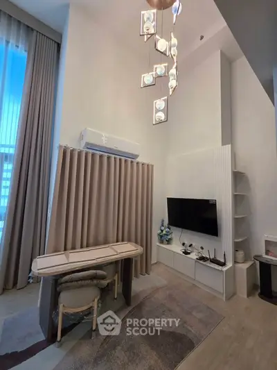 Modern living room with high ceiling, elegant chandelier, and stylish decor in a contemporary apartment.