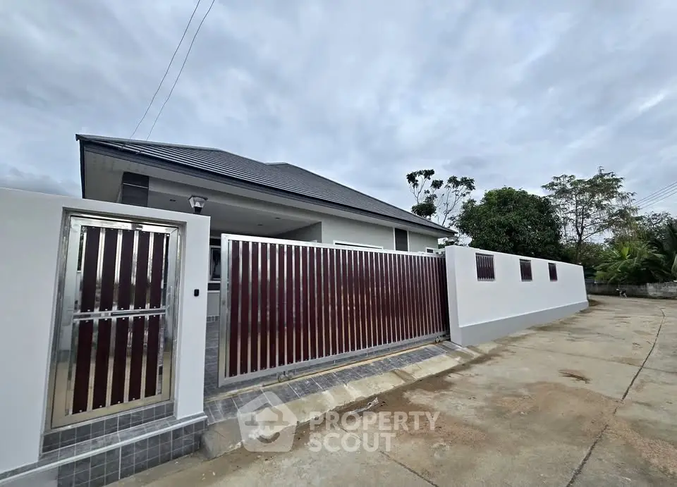 Modern house exterior with sleek metal gate and spacious driveway