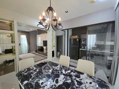 Modern dining area with elegant chandelier and marble table in open-plan living space.