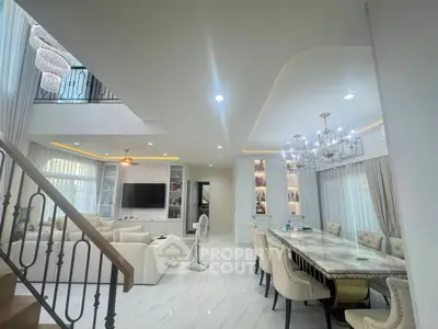Luxurious open-plan living and dining area with elegant chandeliers and modern decor.