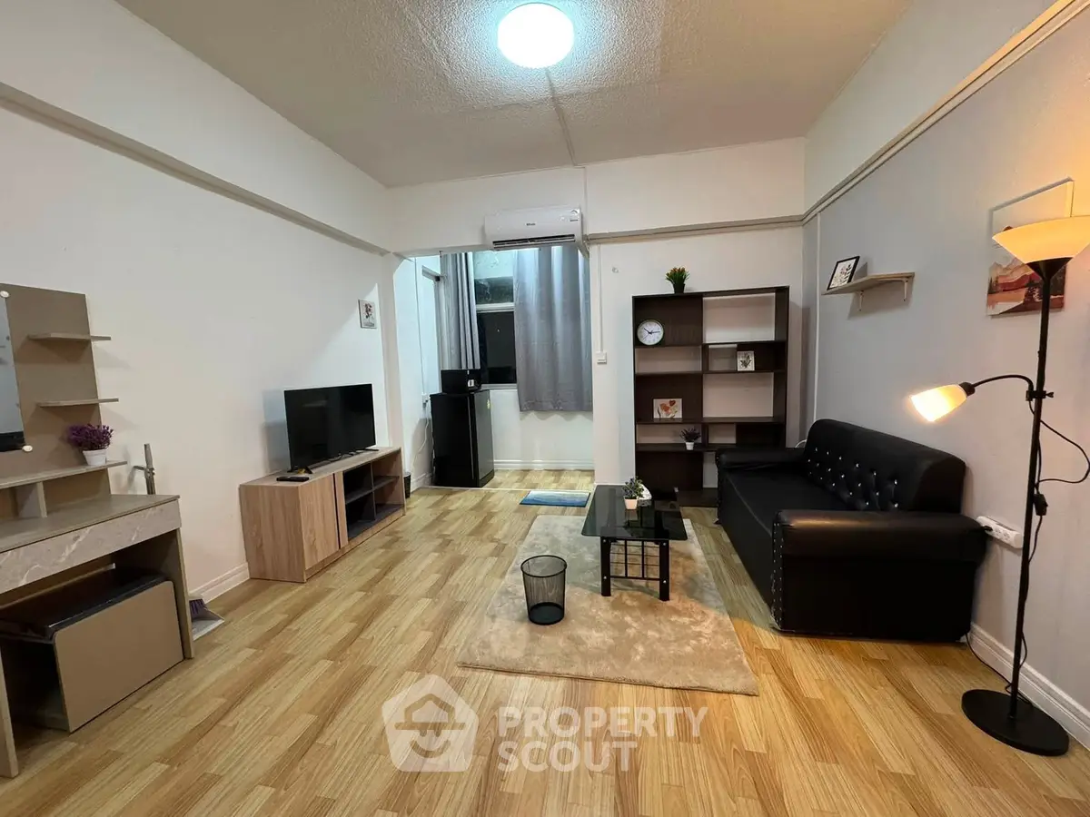 Spacious living room with modern decor and wooden flooring, perfect for relaxation and entertainment.