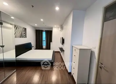 Spacious modern bedroom with mirrored closet and sleek wooden flooring