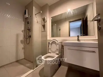 Modern bathroom with sleek fixtures and spacious shower in contemporary apartment.