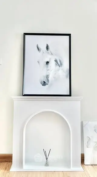 Elegant interior with framed horse artwork above a stylish white mantelpiece.