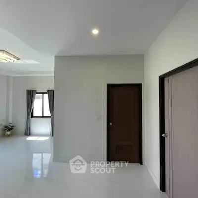 Spacious modern interior with sleek white flooring and elegant lighting.