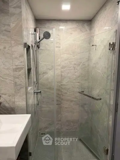 Modern bathroom with glass shower enclosure and sleek fixtures.
