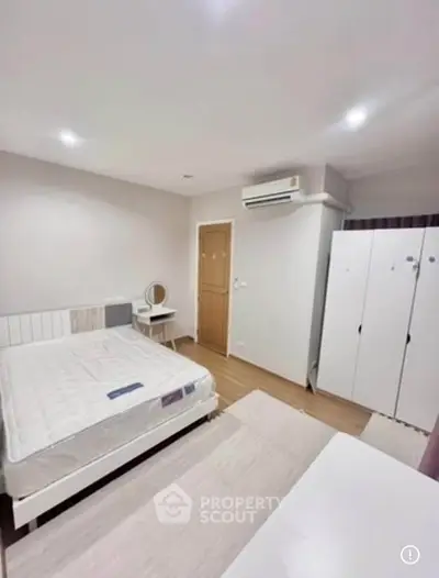 Spacious bedroom with modern furnishings and ample storage in a stylish apartment.