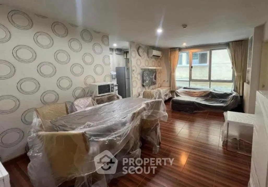 Spacious living room with modern decor and large windows in a stylish apartment.