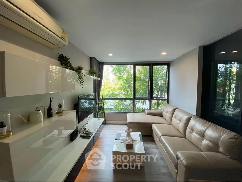 Modern living room with large windows and stylish furniture in a cozy apartment.