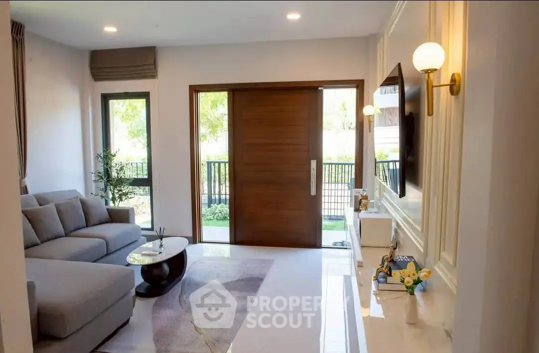 Modern living room with elegant decor and large window offering natural light.