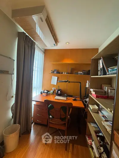 Cozy study room with wooden desk and shelves, perfect for productivity.