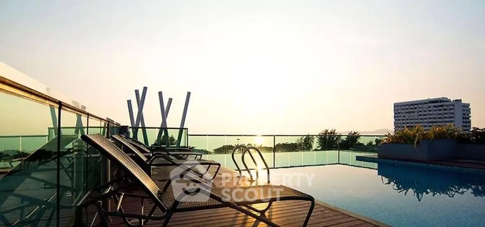 Luxurious rooftop pool with stunning sunset view and modern lounge chairs