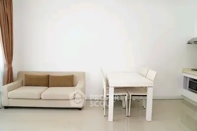 Modern minimalist living room with sleek white furniture and cozy beige sofa.