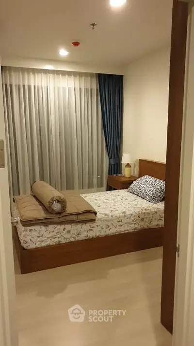 Cozy bedroom with modern decor and elegant curtains, perfect for a restful retreat.