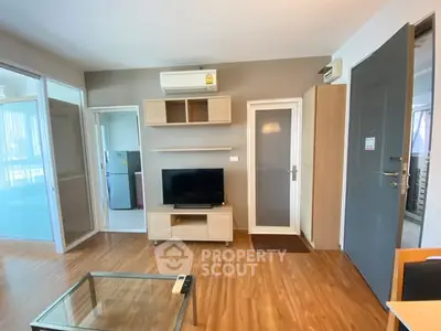 Modern living room with wooden flooring and sleek furniture in a cozy apartment.