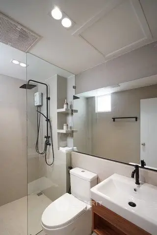 Modern bathroom with glass shower, sleek fixtures, and ample lighting.