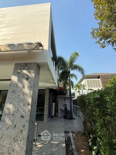 Modern exterior of a luxury home with sleek design and lush greenery