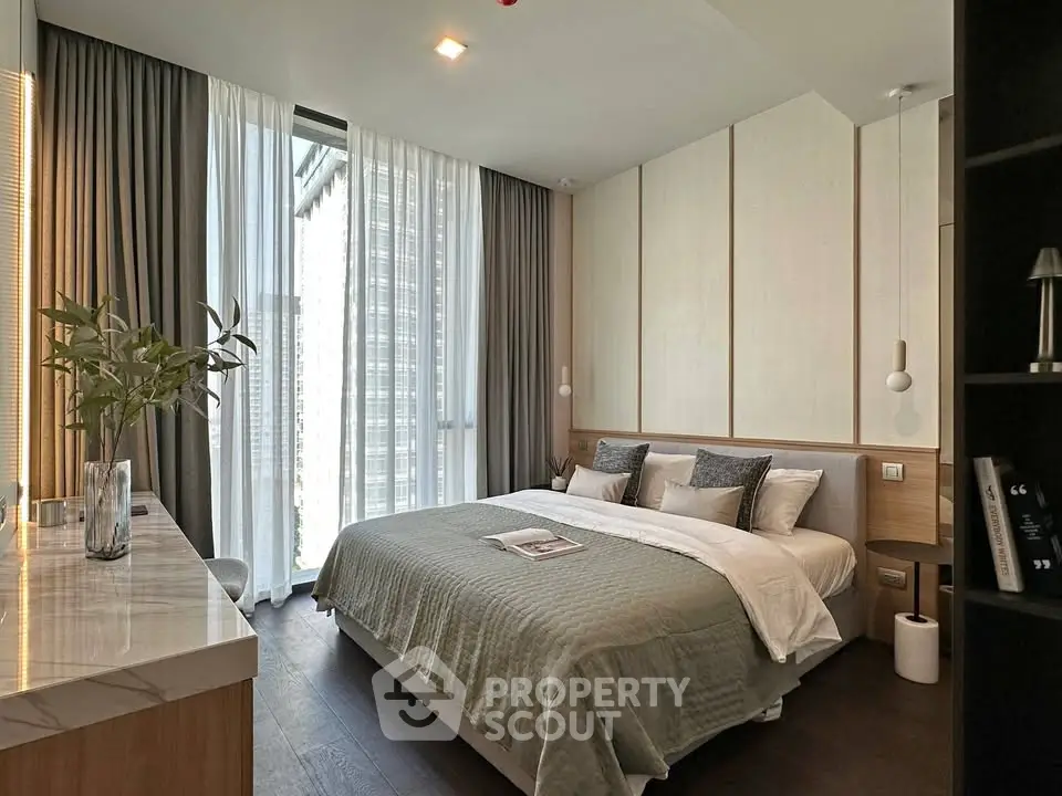 Luxurious modern bedroom with elegant decor and large windows offering natural light.
