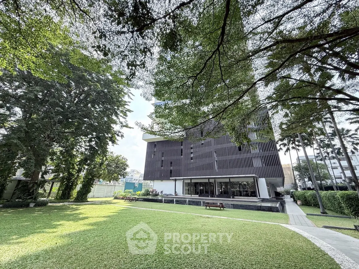 Modern building with lush garden and spacious lawn, perfect for relaxation and outdoor activities.