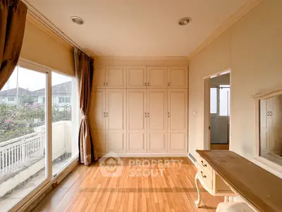 Spacious bedroom with built-in wardrobe and balcony view