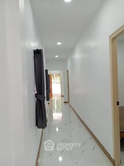 Bright hallway with glossy marble flooring and modern design in a residential property.