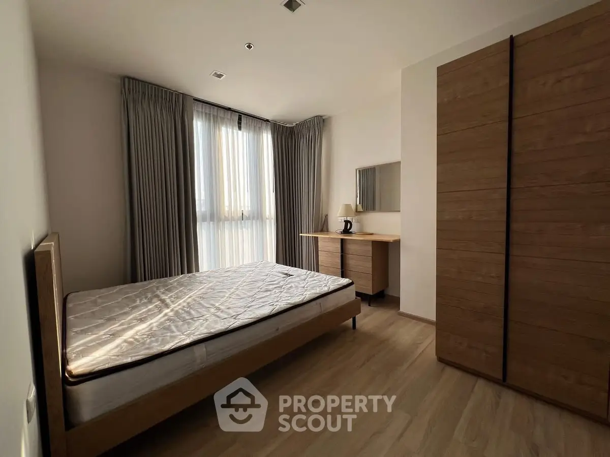 Spacious bedroom with wooden furniture and natural light