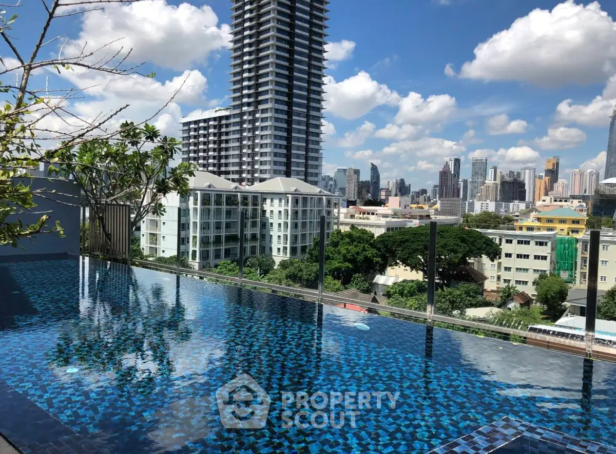 Stunning rooftop pool with city skyline views in a modern high-rise building.