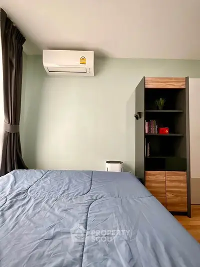 Cozy bedroom with modern air conditioning and stylish storage unit, perfect for comfortable living.